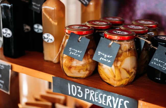 Fermented pears in jars on a shelf.