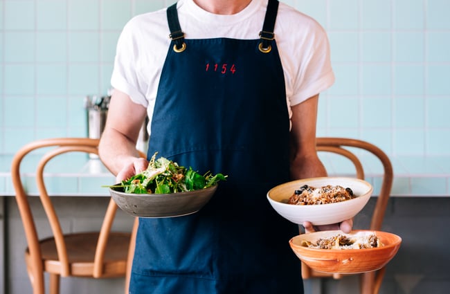 Waiter holds three dishes at 1154, Wellington.