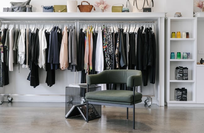 A chair in front of racks of clothing inside 47 Frocks in Wānaka.