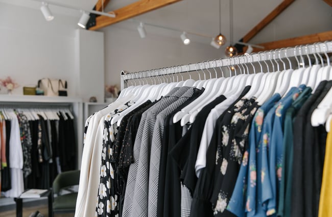 A close up of clothing hanging on white coat hangers at 47 Frocks.
