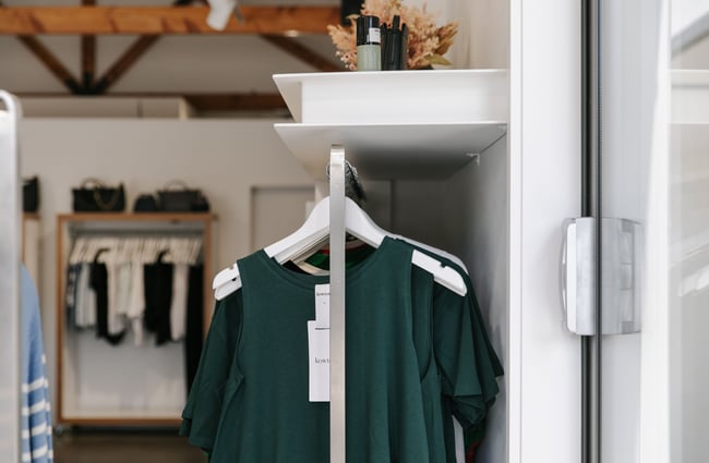 A close up of a dark green singlet hanging on a rack.