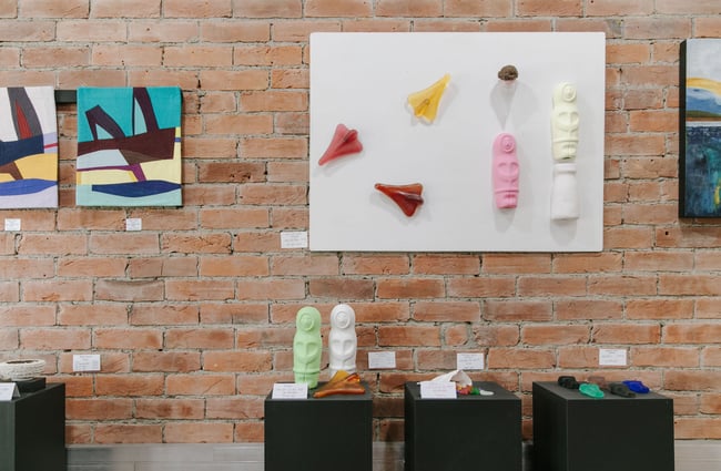 Colourful works of art including eskimos and jet planes on display on walls and plinths at 77 Art + Living in Fairlie.