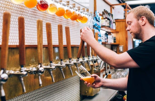Close up of a man pouring a beer.