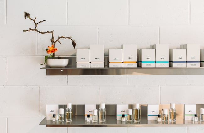 White perfume boxes displayed on a steal shelf.