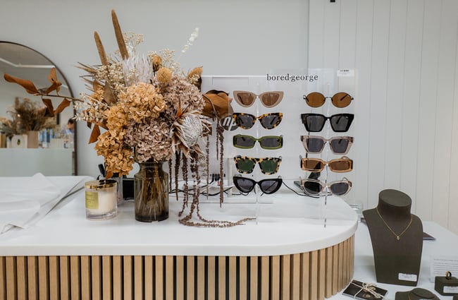 Sunglasses and dried flowers on a counter.