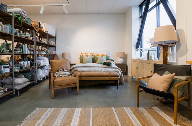 A bed and soft furnishings on display for sale inside Addy and Lou.