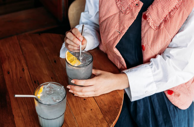 Close up of two glasses of lemon soda on a wooden table.