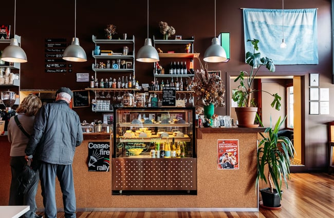 Two customers ordering up at the counter inside ADJØ.