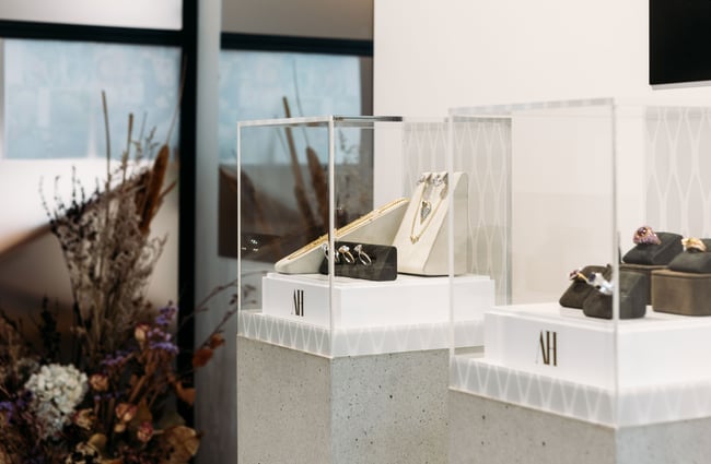 A close up of glass displays showing diamond rings.