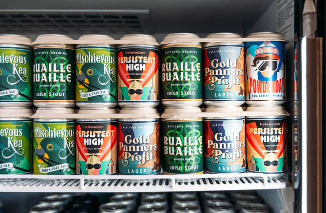A close up of beer cans in the fridge.