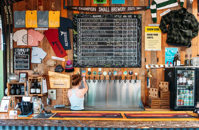 A staff member pouring beer behind the counter.