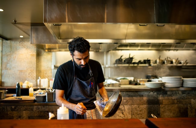 A male staff member working with a pan.