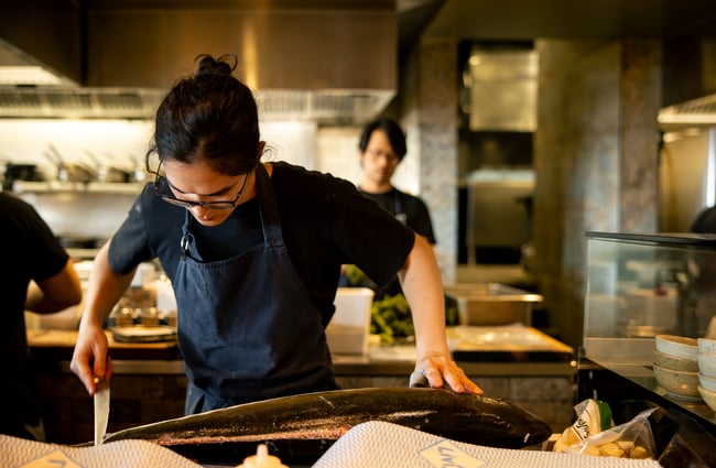 A chefcutting into a large fish.