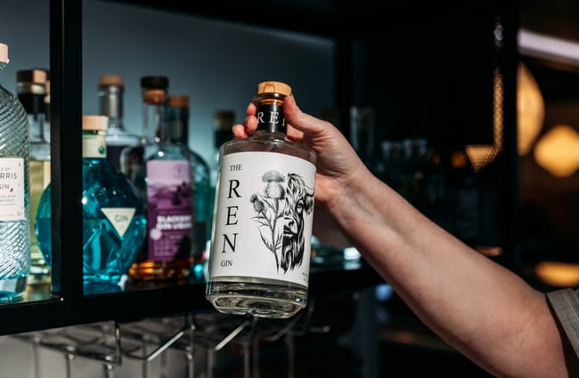 Bartender holding a bottle of alcohol at Amayjen.