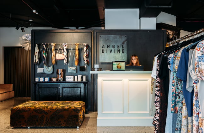 A staff member working behind a white counter at Angel Divine.