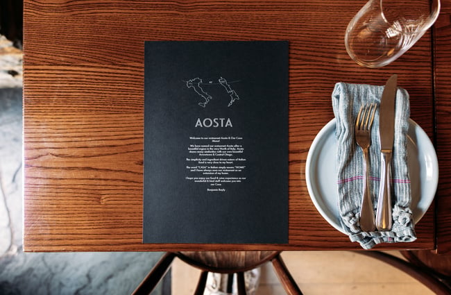 The close up of a black menu on a table.
