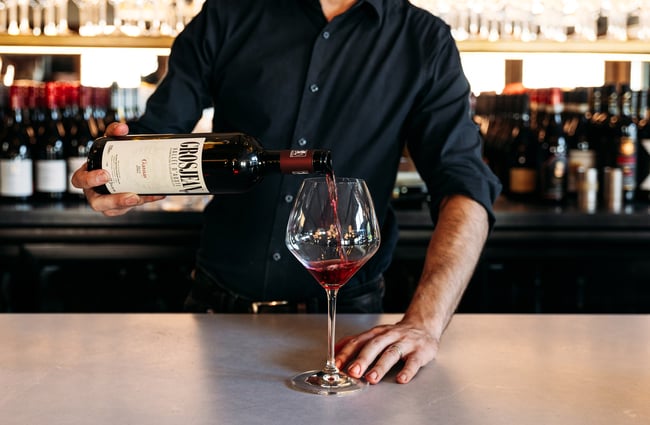 A glass of red wine being poured into a glass.