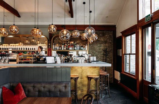 A staff member working behind the counter at Aosta Arrowtown.