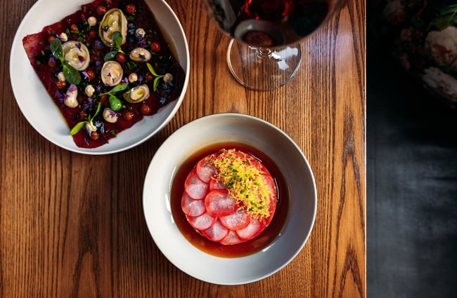 A birdseye view of food and wine on a table.
