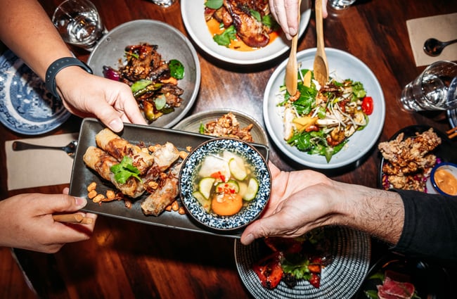 People passing food dishes across the table at Apache.