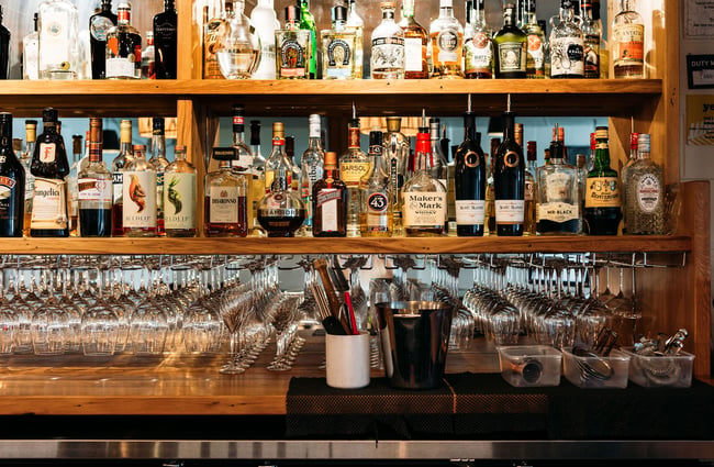 Close up of the spirits on the shelves and glassware at the bar in arc.