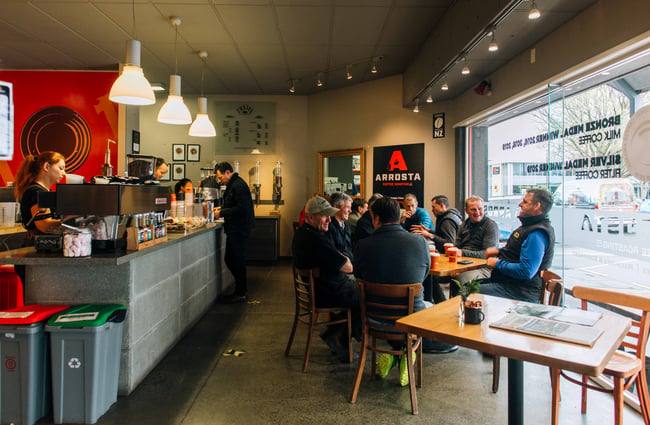 People sittting at tables inside the cafe.