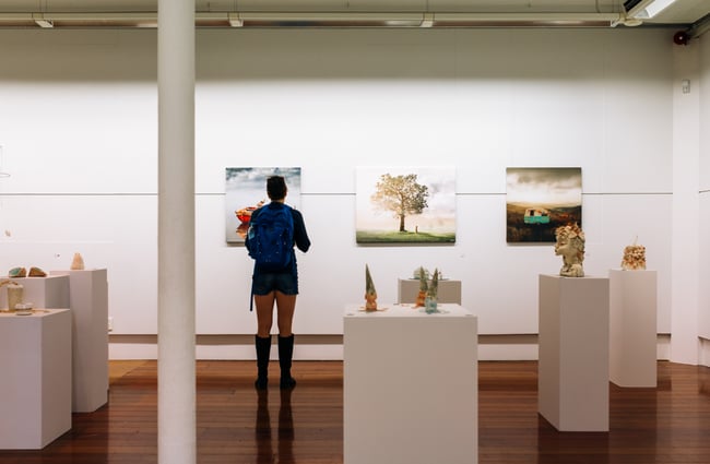 Woman looks at art at ArtsPost Gallery and Shop Hamilton.