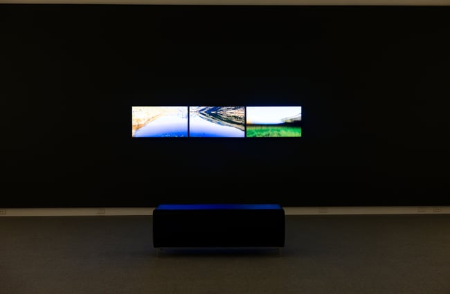 Three pictures on TV screens inside a dark room.