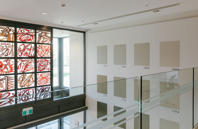 A view of art on a wall photographed from the first floor of the Ashburton Art Gallery.