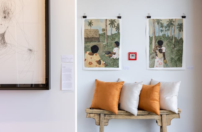 Art hangs on the walls in the background, with cushions lined on a shelf at Ashe.