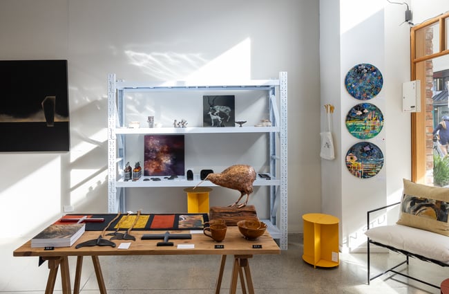 Shelves and display table with various art items at Ashe.