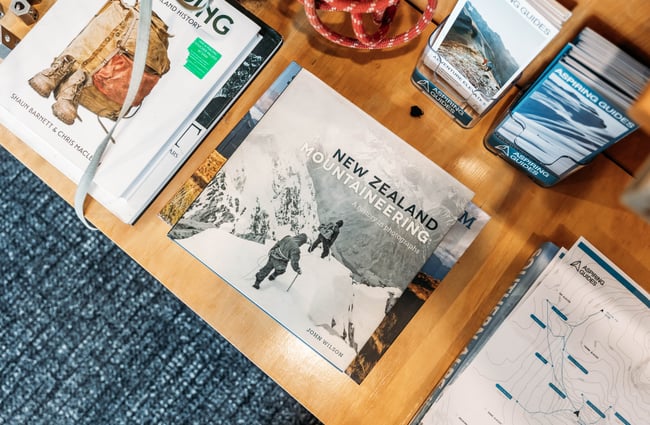 Climbing and mountaineering books on a table at the reception at Aspiring Guides.
