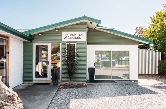 Green weatherboard building exterior of Aspiring Guides.