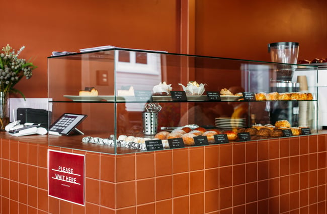 The glass food cabinet filled with pastries and sweets.