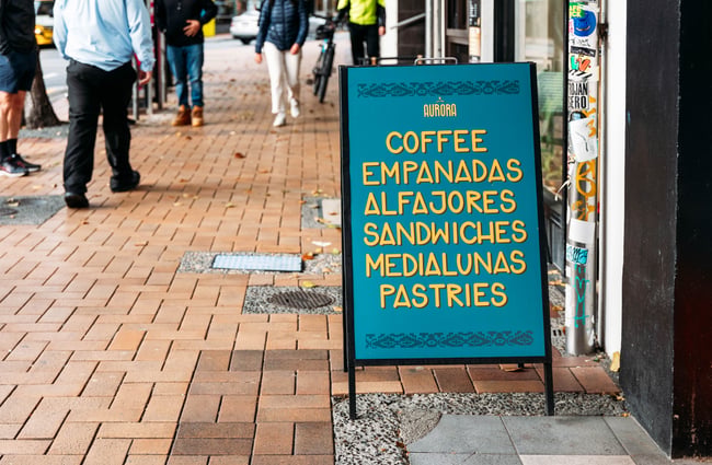 Sign outside the bakery advertising what is for sale at Aurora Argentinian Bakery.
