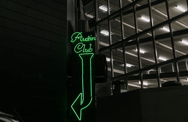 Austin Club exterior neon green sign.