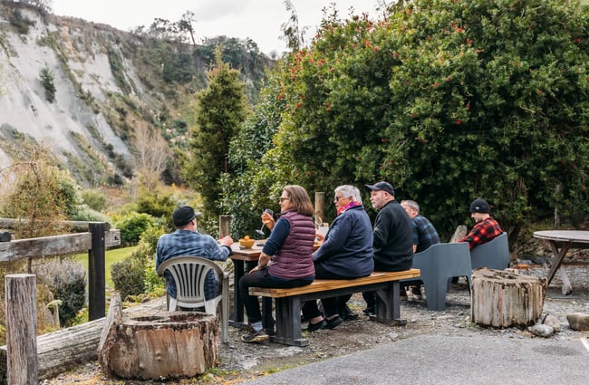 People sitting outside on a table at Awastone in Rangitikei.