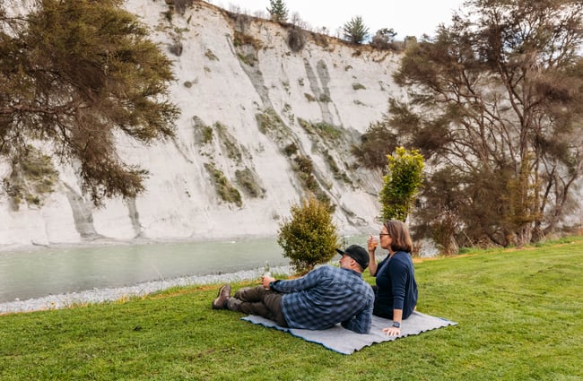 Two people sitting on grass at Awastone in Rangitikei.