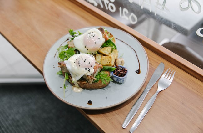 A close up of eggs and potato on a toast.