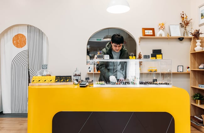 A man behind a yellow counter.