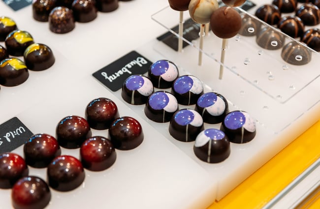 A close up of round chocolates on a counter.