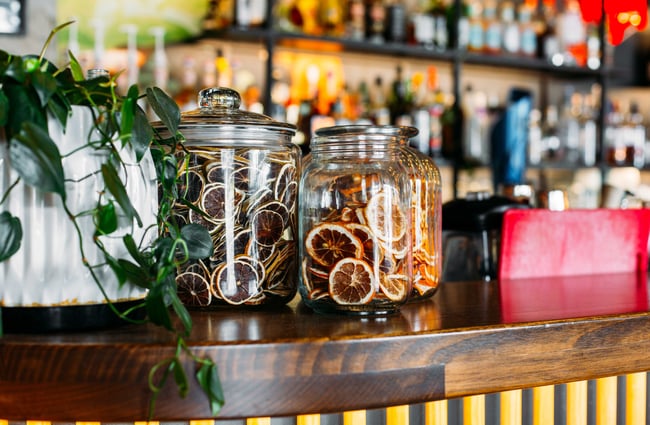 Dried critics fruits of orange and grapefruit in big glass jars.