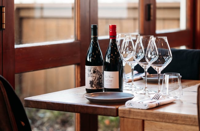 A close up of a wine glass and wine glasses on a table.