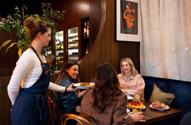 Wait staff serving food to a table at Bar Franco.