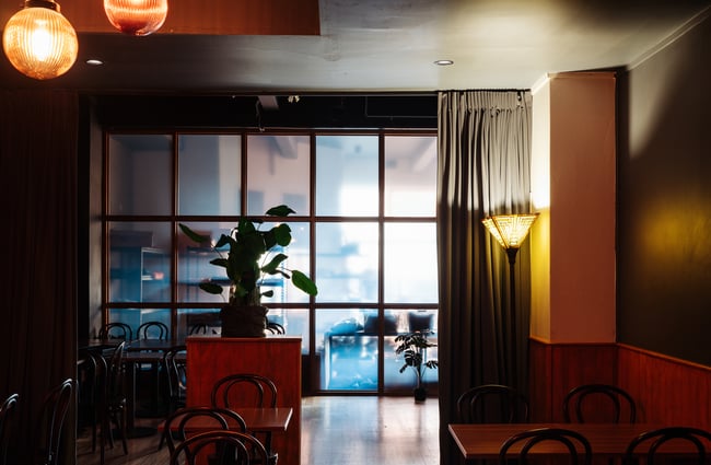 A back lit glass wall at one end of the restaurant space.