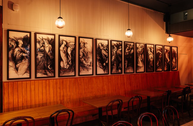 Black and white works of art lined up on a wall.