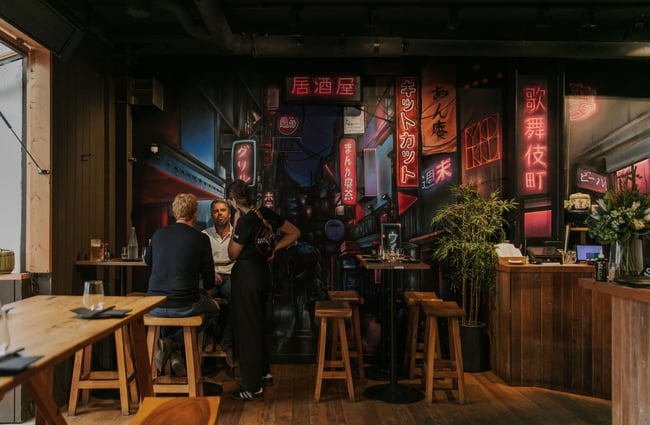 Customers sitting at a table inside a dark restaurant.