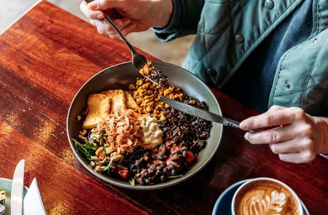 Customer eating a breakfast dish at Barista.
