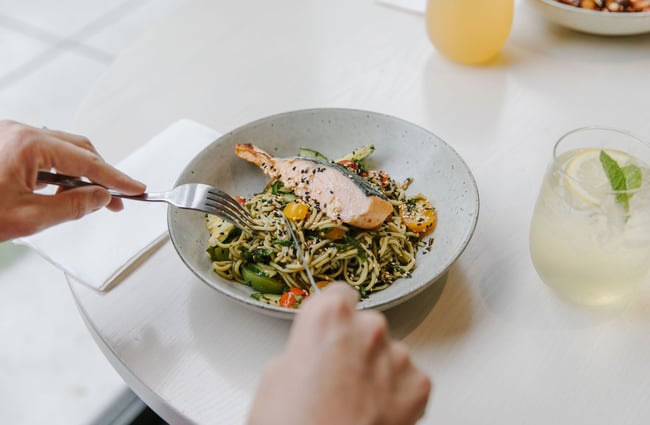 Close up of someone eating salmon and noodle dish from Barker's Foodstore and Eatery, Geraldine.
