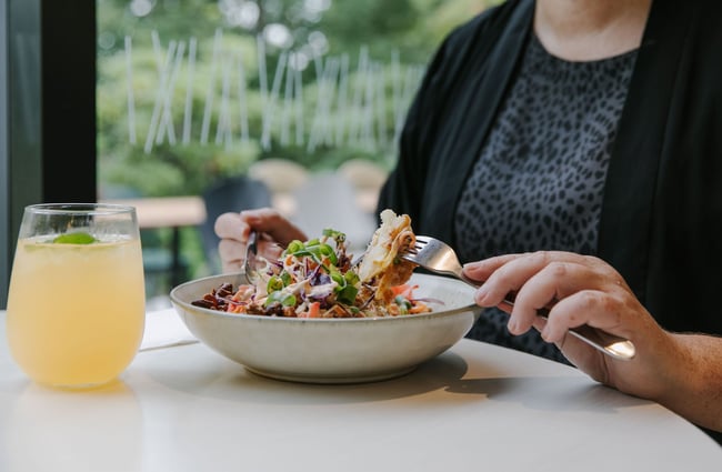 Woman eating salad dish at Barker's Foodstore and Eatery, Geraldine.